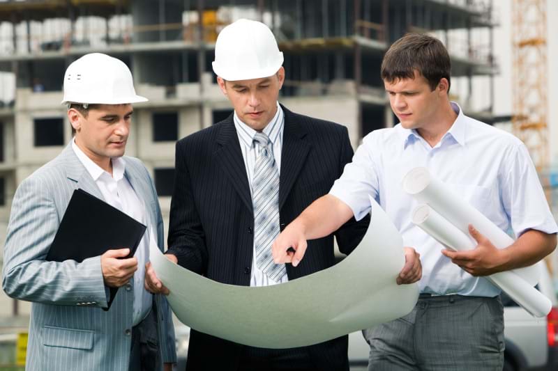 Men in hardhats looking at blueprints